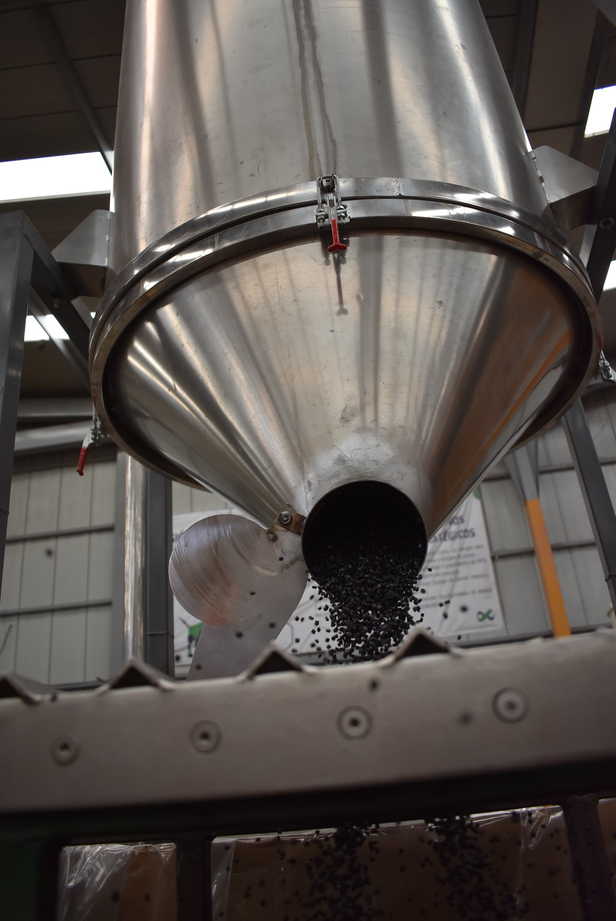Pellet negro descargándose desde una tolva en la planta de PIMSA